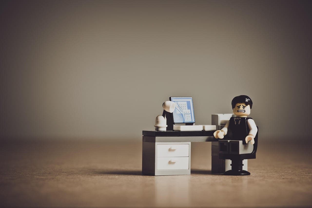 An office worker looking frustrated at a computer screen