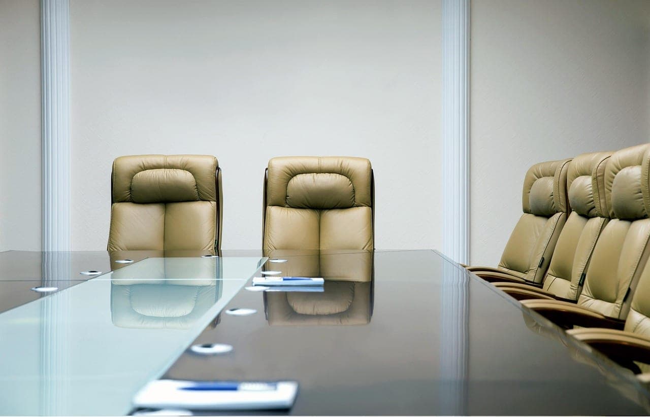 A person presenting a document to a group of colleagues in a boardroom