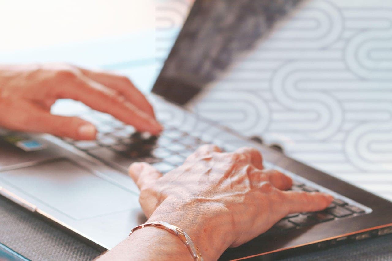 Typing on a laptop keyboard in a modern office