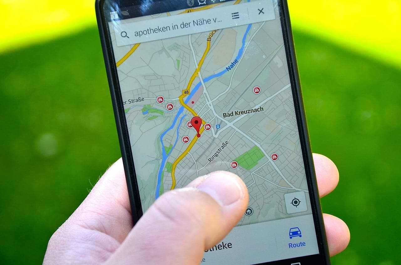 A person holding a smartphone showing local map search results for restaurants
