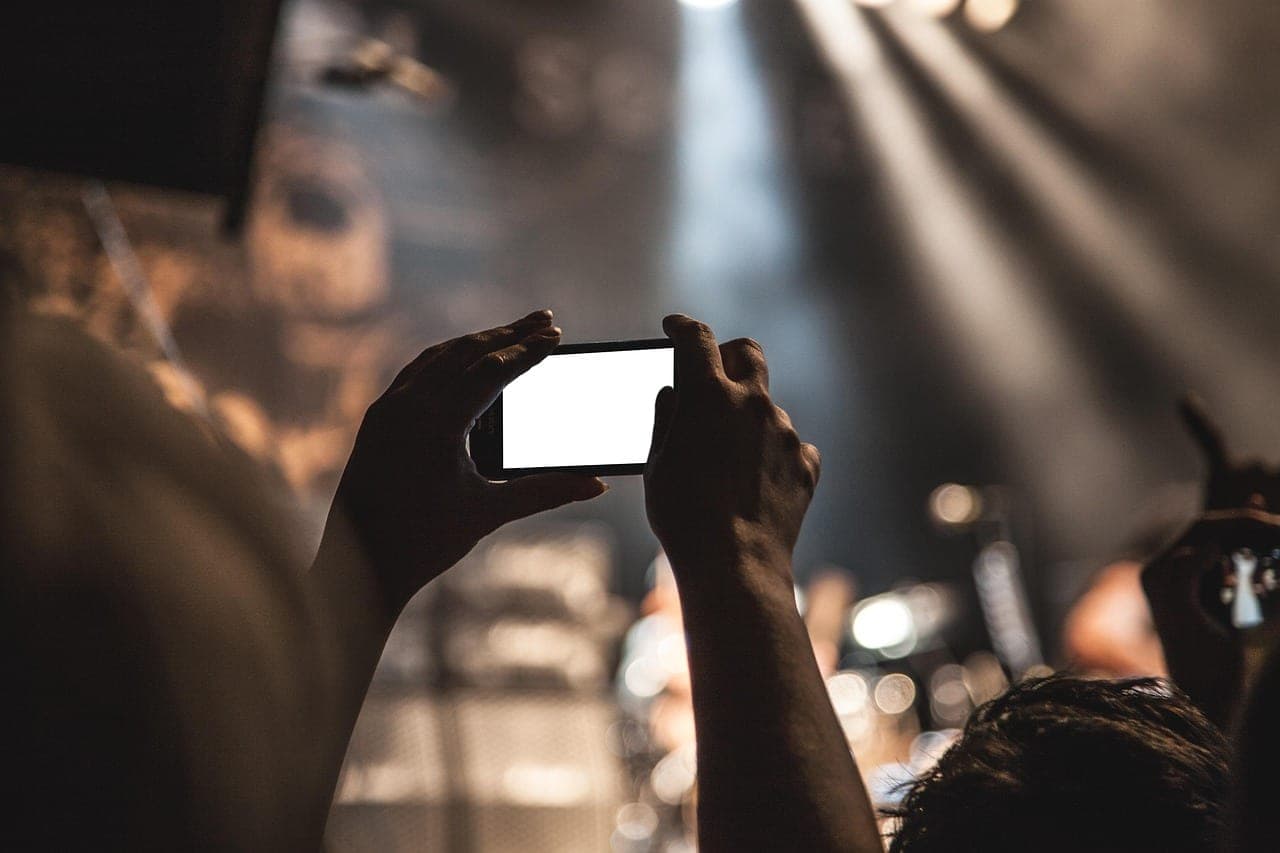 A person holding a smartphone showing a search engine interface.